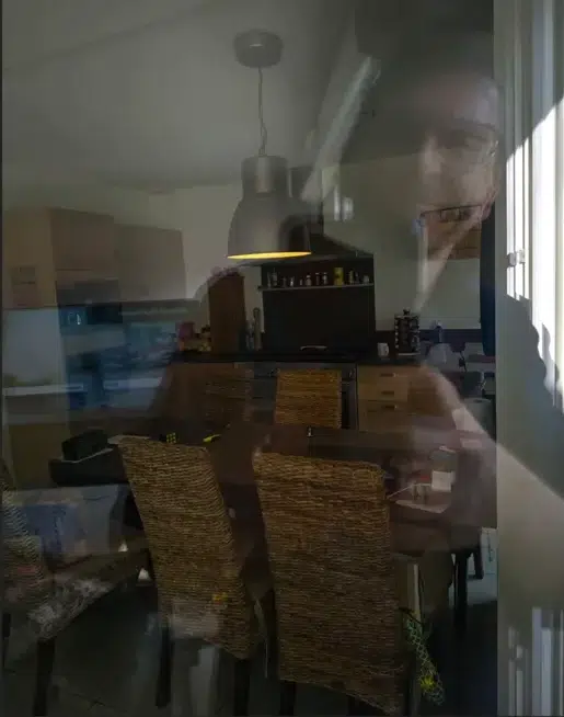 Reflet du photographe visible dans une vitre de cuisine.